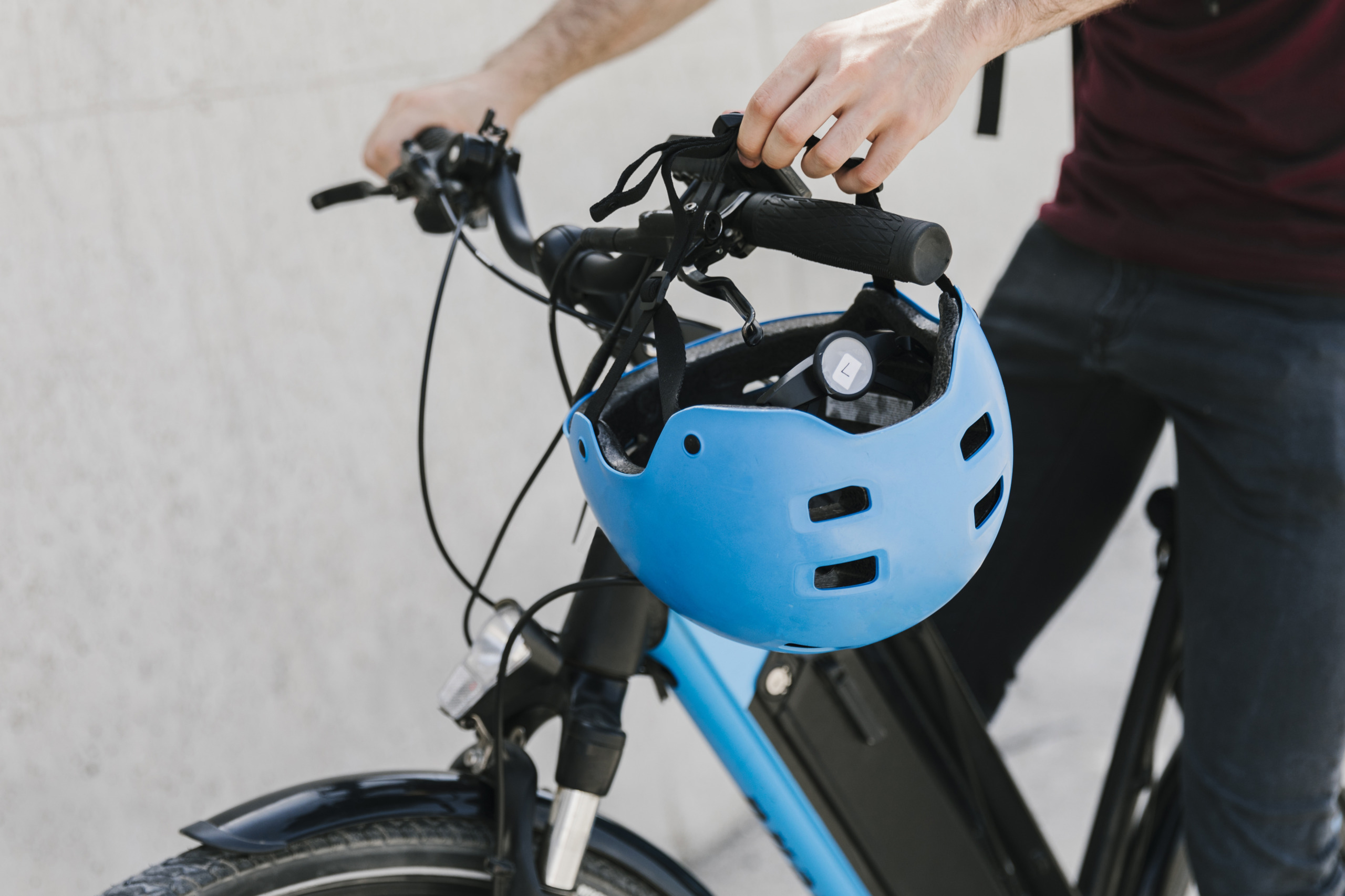 close-up-bicyclist-putting-helmet-bycicle-handle close up bicyclist putting-helmet bycicle handle scaled.jpg